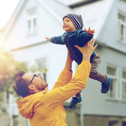 father and child in front of home